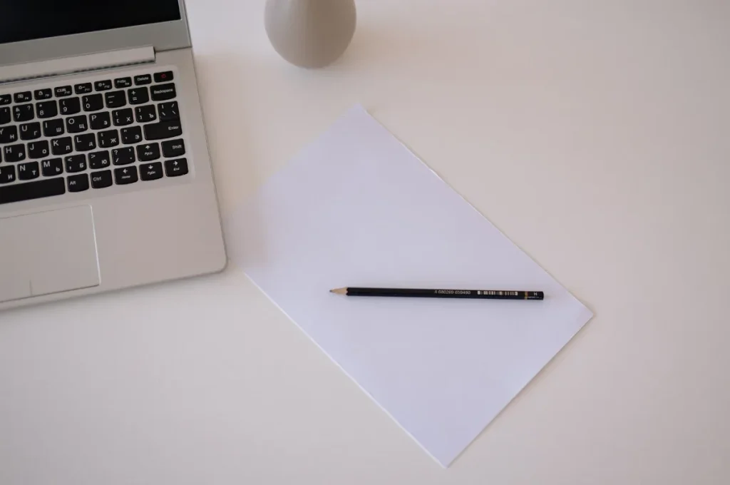 Calon copywriter berlatih menulis di meja kerja dengan laptop dan buku catatan