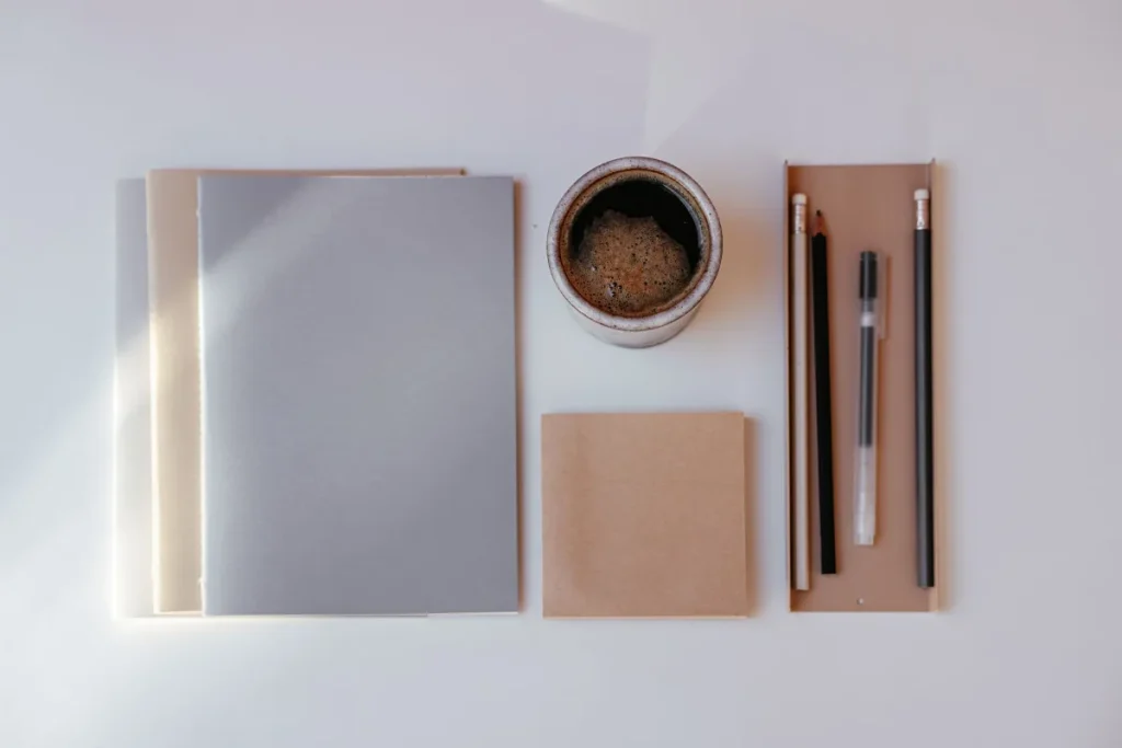 Latihan menulis copy singkat dengan kopi, laptop, dan buku catatan