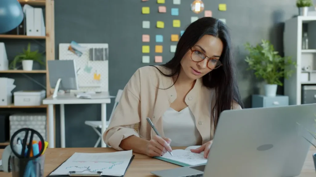 Copywriter muda menyusun ide dan catatan riset di meja kerja