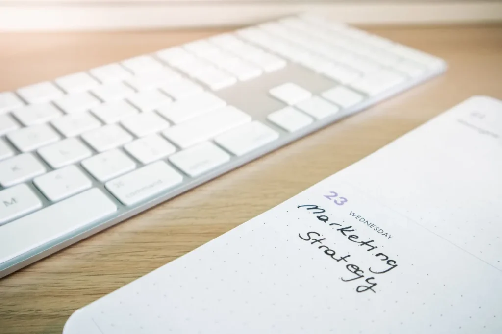 Copywriter menyusun rencana tulisan dengan catatan dan laptop di meja