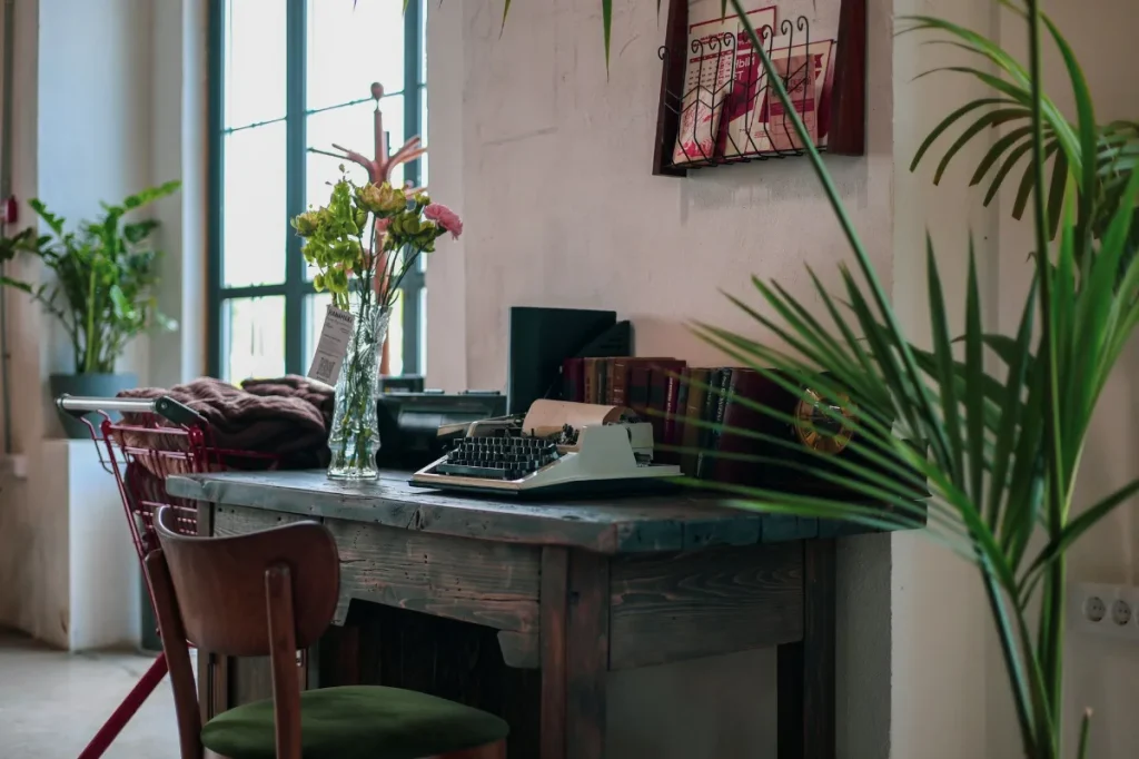 Meja kerja copywriter dengan laptop, kalkulator, dan catatan untuk menghitung harga proyek