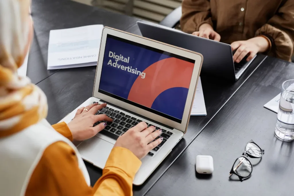 Profesional muda menyusun copy iklan media sosial di laptop