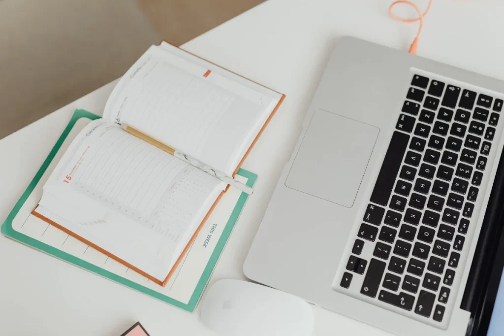 Meja kerja dengan laptop dan catatan saat merancang promosi ebook