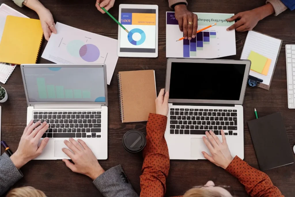 Pemasar menyusun tujuan kampanye iklan di laptop dan buku catatan