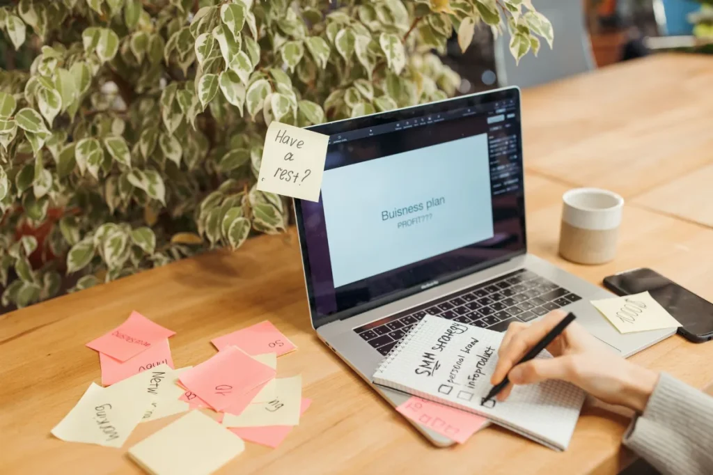 Meja kerja dengan notebook dan laptop untuk menyusun elemen brief copywriting