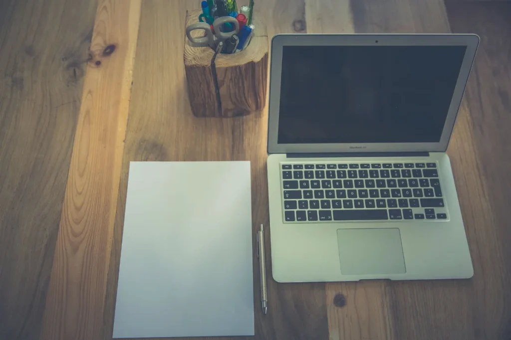 Copywriter pemula meninjau catatan proyek dan pekerjaan di laptop