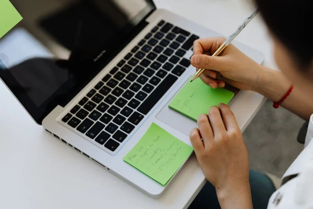 Meja kerja copywriter dengan laptop, catatan riset, dan draf tulisan