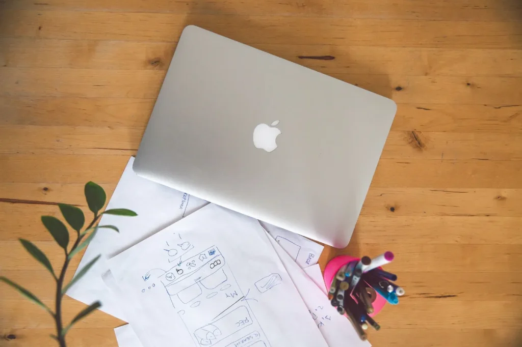 Laptop dan catatan di meja kerja saat menata struktur portofolio copywriting