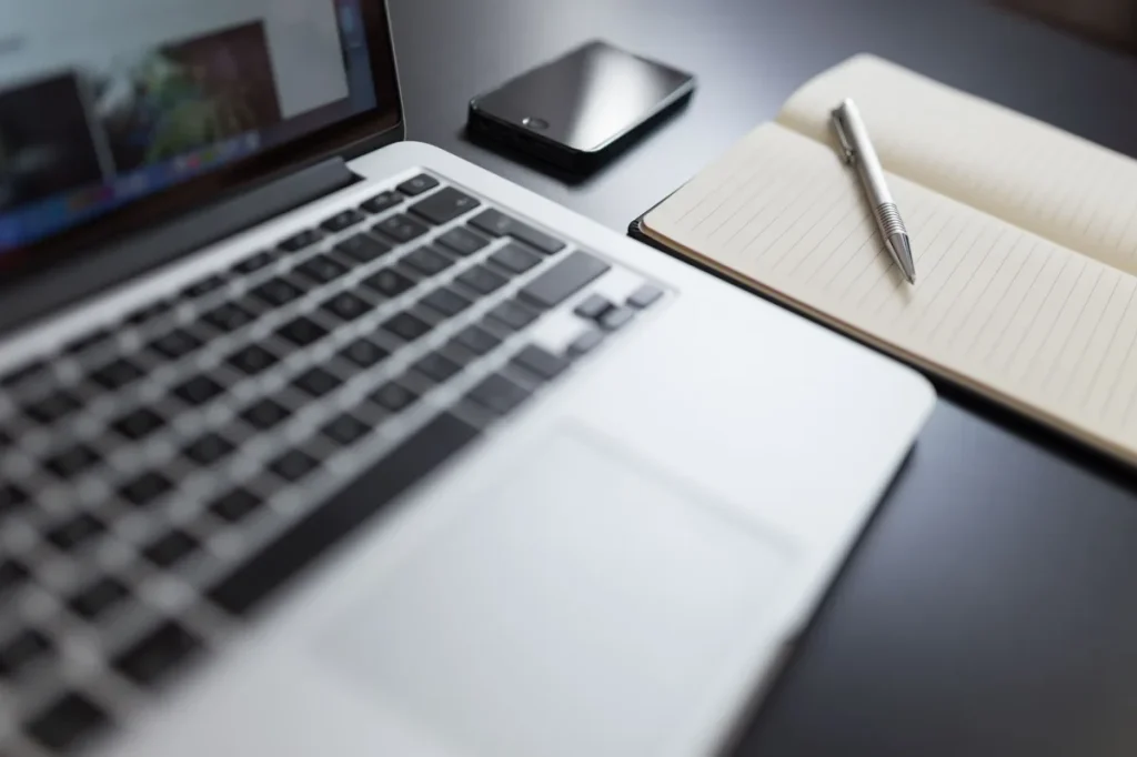 Copywriter menghitung harga proyek sambil meninjau catatan kerja di meja